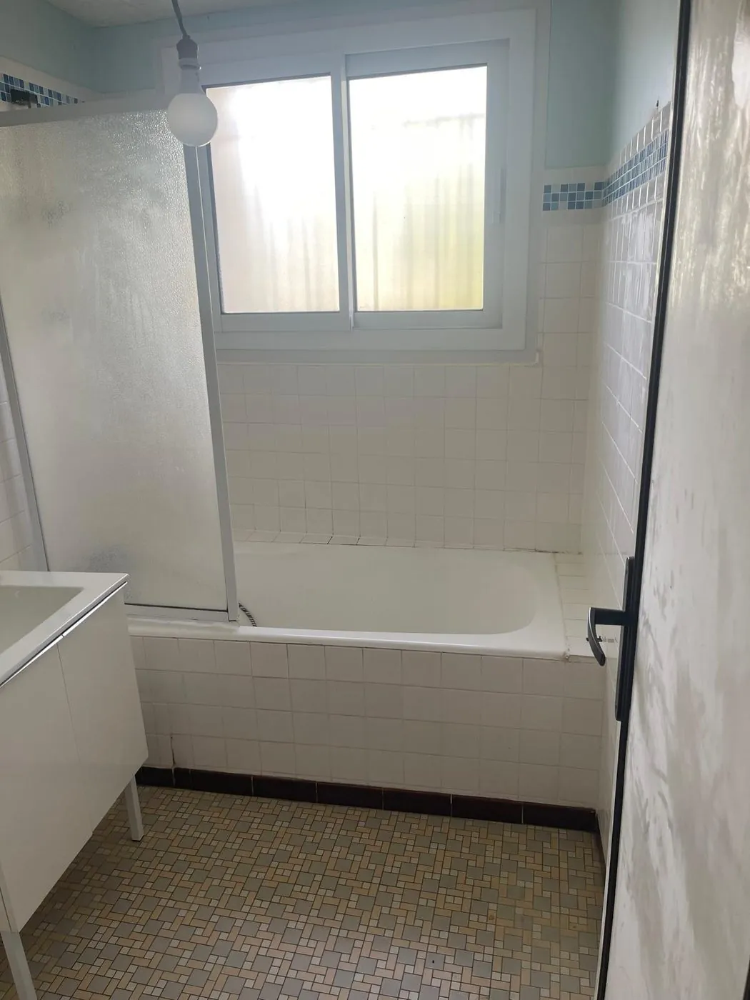 Avant travaux — Rénovation complète : dépose de la baignoire, douche à l'italienne, faïence décor végétal, meuble et sol grès cérame terracotta.