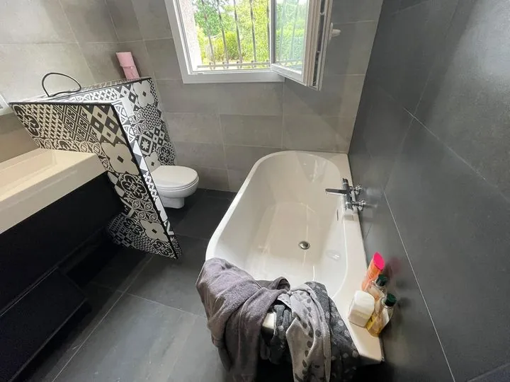 Baignoire îlot, sol ardoise grand format et muret en carreaux de ciment