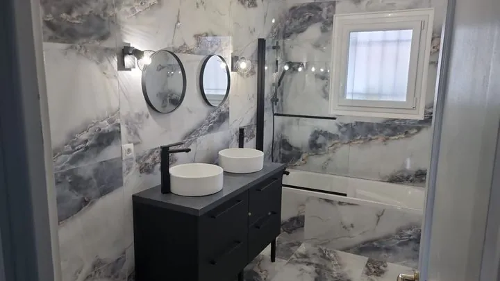 Salle de bains effet marbre bleu-gris, double vasque et robinetterie noire