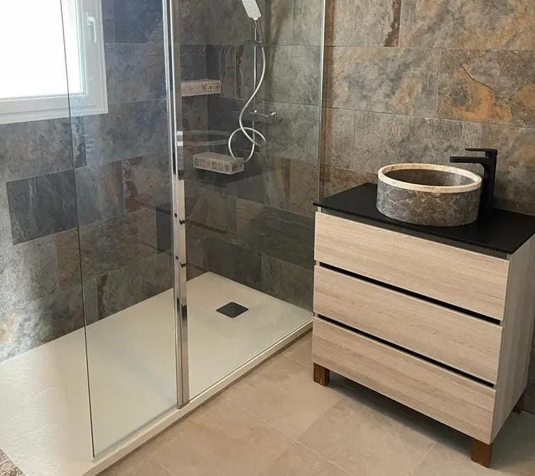 Douche à l'italienne en grès cérame effet ardoise et vasque en pierre naturelle posées par Atout Carrelage
